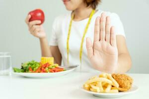 belleza Delgado hembra cuerpo confundir francés papas fritas y frito pollo. mujer en restaurante logra peso pérdida objetivo para sano vida, loco acerca de delgadez, Delgado cintura, nutricionista. dieta, cuerpo forma. foto