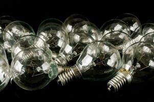 a group of clear light bulbs on a black surface photo