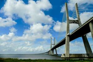 the bridge spans over the water with a blue sky photo