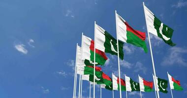 Pakistan and Madagascar Flags Waving Together in the Sky, Seamless Loop in Wind, Space on Left Side for Design or Information, 3D Rendering video