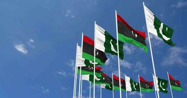 Paquistão e Líbia bandeiras acenando juntos dentro a céu, desatado ciclo dentro vento, espaço em esquerda lado para Projeto ou Informação, 3d Renderização video