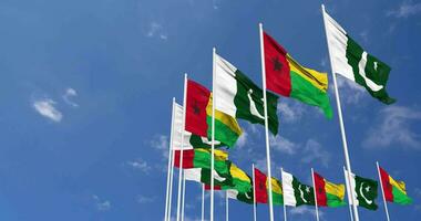 Pakistan e Guinea bissau bandiere agitando insieme nel il cielo, senza soluzione di continuità ciclo continuo nel vento, spazio su sinistra lato per design o informazione, 3d interpretazione video