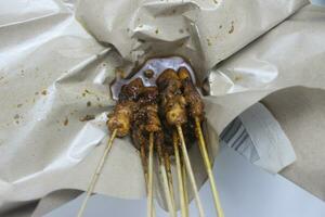 diez brochetas de tradicional pollo satay ensartado con afilado bambú palos foto
