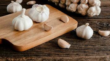 organic Raw garlic bulb, garlic cloves on a wooden cutting board on a wooden table and garlic cloves of food ingredients photo