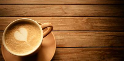 en forma de corazon café latté en un marrón taza con un platillo, metido en un antiguo de madera mesa. ese es Listo a dar usted frescura cada Mañana. foto