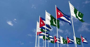 Pakistan e Cuba bandiere agitando insieme nel il cielo, senza soluzione di continuità ciclo continuo nel vento, spazio su sinistra lato per design o informazione, 3d interpretazione video