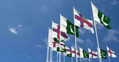 Pakistan and Faroe Islands Flags Waving Together in the Sky, Seamless Loop in Wind, Space on Left Side for Design or Information, 3D Rendering video