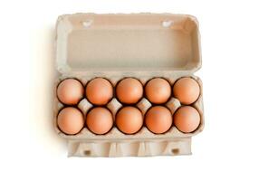 Open box with fresh brown eggs isolated on white background, clipping path. Fresh organic chicken eggs in carton box. photo