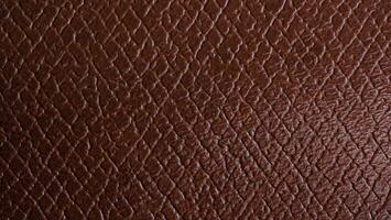 Close-up genuine leather texture, square checkered. Reddish brown color, natural wrinkled texture wallpaper pattern. leather accessory production concept. photo