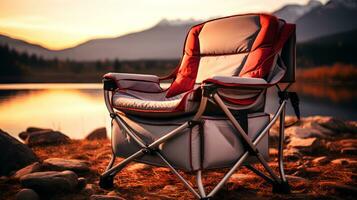 AI generated Camping chair on the shore of a lake with mountains in the background. photo