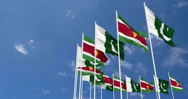 Pakistan and Suriname Flags Waving Together in the Sky, Seamless Loop in Wind, Space on Left Side for Design or Information, 3D Rendering video