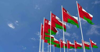 Oman drapeaux agitant dans le ciel, sans couture boucle dans vent, espace sur la gauche côté pour conception ou information, 3d le rendu video