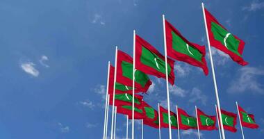 Maldives drapeaux agitant dans le ciel, sans couture boucle dans vent, espace sur la gauche côté pour conception ou information, 3d le rendu video