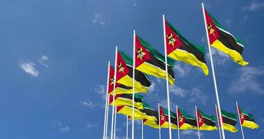 Mozambique banderas ondulación en el cielo, sin costura lazo en viento, espacio en izquierda lado para diseño o información, 3d representación video