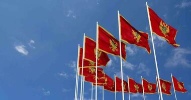 montenegro bandiere agitando nel il cielo, senza soluzione di continuità ciclo continuo nel vento, spazio su sinistra lato per design o informazione, 3d interpretazione video