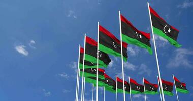 Libia bandiere agitando nel il cielo, senza soluzione di continuità ciclo continuo nel vento, spazio su sinistra lato per design o informazione, 3d interpretazione video