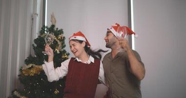 retrato de joven Pareja en amor danzado alegremente y Bebiendo champán en un decorado con navidad hogar, celebrando Navidad y nuevo año. amantes tener momento romántico y contento juntos foto