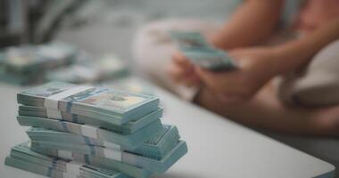 Portrait close up of young asian woman counts cash dollar bills while sitting in living room at home,counting stack cash money dollar, Financial planning. photo