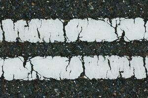 Old white traffic lines on the road. photo