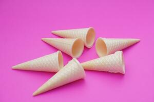 Empty crispy waffle ice cream cones isolated on pink background. Concept, part of pattern of ice creams in cone shape. Snack and dessert. copy space for text. photo