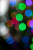 Round green, blue, pink and white festive Christmas bokeh lights on dark Holiday vertical background photo