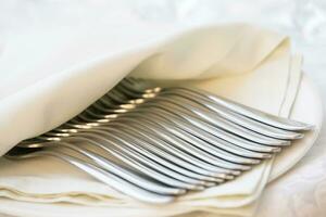 Many forks wrapped in a white napkin photo