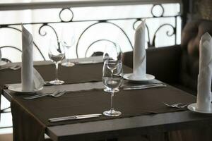 Table in a restaurant with empty glasses and plates. photo