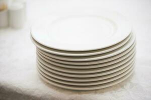 A stack of white plates on the table photo
