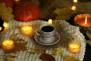 cup of coffee on the autumn background with leaves and candles photo