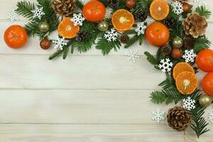 white wooden winter background with christmas decorations, tangerines, cones and copy space photo