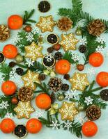 Blue winter background with pattern of christmas decorations, tangerines, cones, gingerbread photo