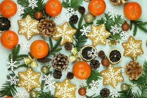 Blue winter background with pattern of christmas decorations, tangerines, cones, gingerbread photo