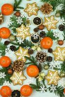 Blue winter background with pattern of christmas decorations, tangerines, cones, gingerbread photo