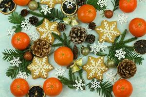 Blue winter background with pattern of christmas decorations, tangerines, cones, gingerbread photo