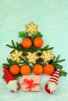 Blue winter background with pattern of christmas decorations, tangerines, cones, gingerbread photo
