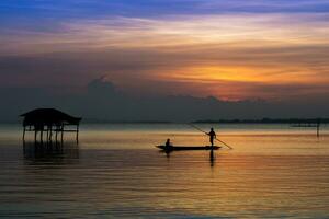 Fishermen and fishing boats float in the lake. photo