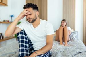 Couple With Problems Having Disagreement In Bed. Frustrated couple arguing and having marriage problems, Young couple into an argument on bed in bedroom photo