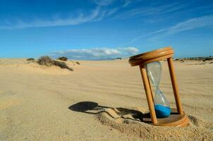 an hourglass on the beach sand photo