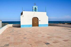 a small chapel with a cross on top of it photo