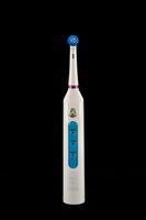 a white electric toothbrush with blue and purple buttons photo