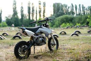 Black vintage custom motorcycle motorbike caferacer standing in the forest road during sunset photo