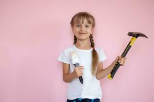 construction and people concept - smiling little girl with hammer photo