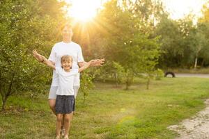 Mother and daughter having fun in the park. Happy family concept. Beauty nature scene with family outdoor lifestyle. Happy family resting together. Happiness and harmony in family life. photo