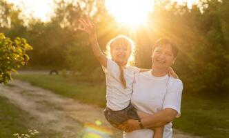 Mother and daughter having fun in the park. Happy family concept. Beauty nature scene with family outdoor lifestyle. Happy family resting together. Happiness and harmony in family life. photo