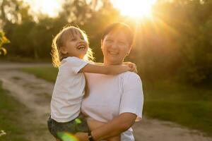 Mother and daughter having fun in the park. Happy family concept. Beauty nature scene with family outdoor lifestyle. Happy family resting together. Happiness and harmony in family life. photo