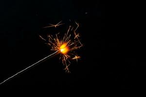 A lit sparkler showing bright sparks photo