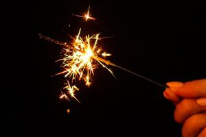 A lit sparkler showing bright sparks photo