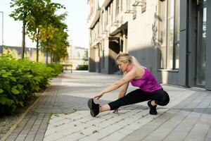 Fitness sport woman in fashion sportswear doing yoga fitness exercise in the street, outdoor sports, urban style photo