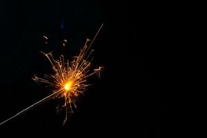 A lit sparkler showing bright sparks photo