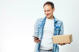 Smiling delivery man giving cardbox on white background photo